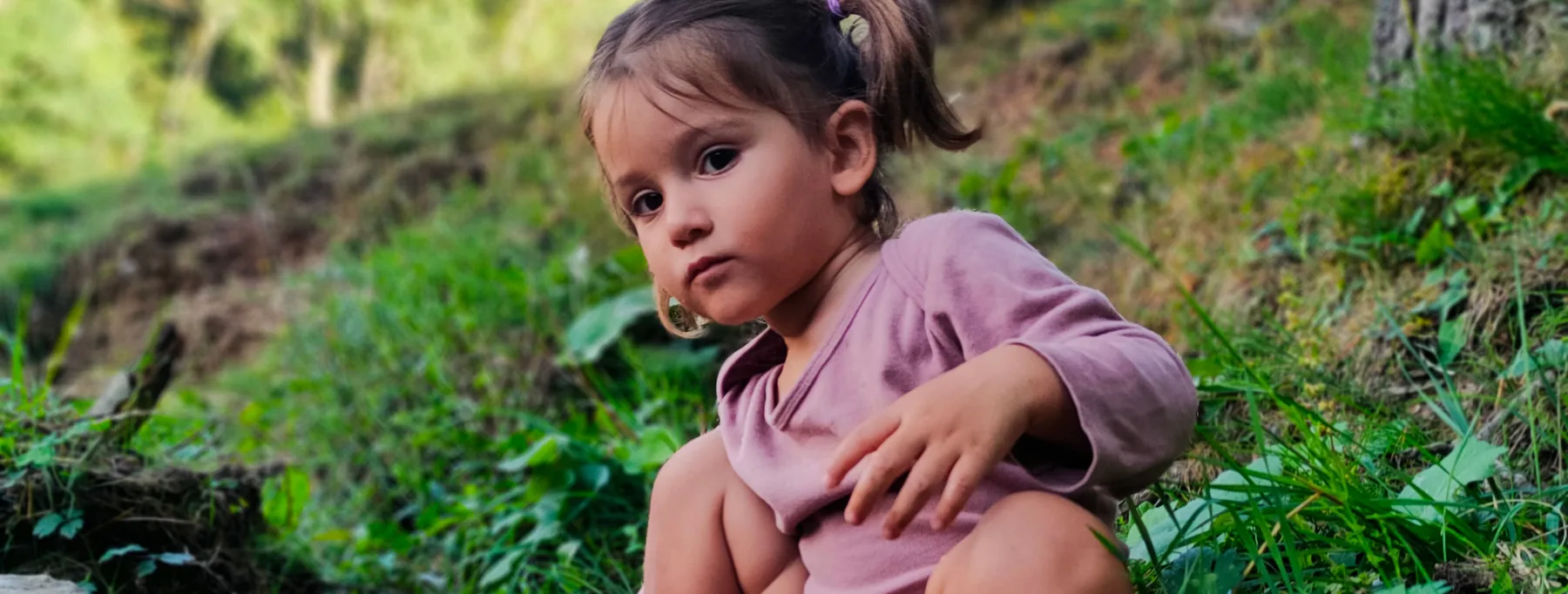 Niña explorando las piedras junto a un arroyo en La Molina